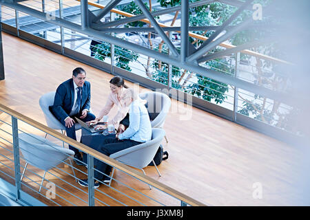 High angle view of businessmen and businesswoman meeting on office balcony Stock Photo