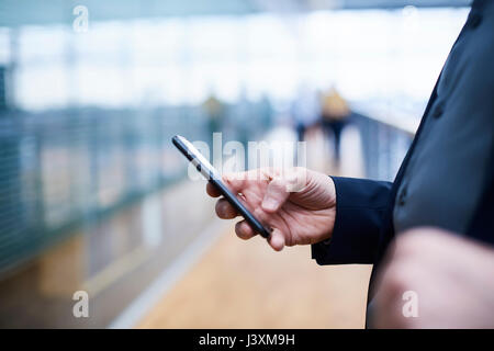 Close up of businessman using smartphone on office balcony Stock Photo