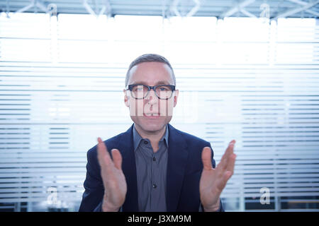 Mature businessman doing presentation in front of office window Stock Photo