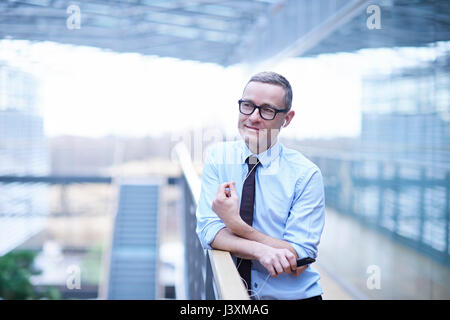 Mature businessman making smartphone call using headset on office balcony Stock Photo