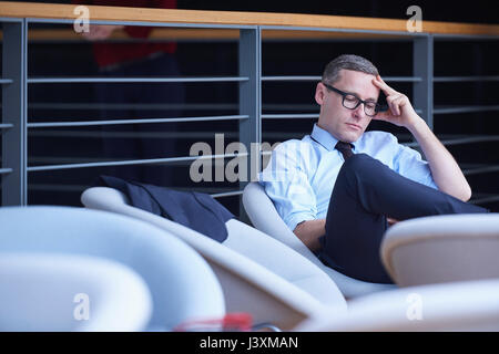 Businessman sitting reading on office balcony Stock Photo