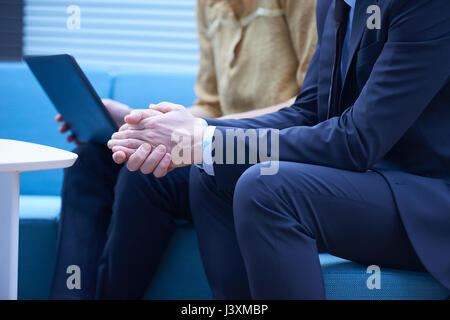 Mid section of businesswoman and man using laptop in meeting Stock Photo