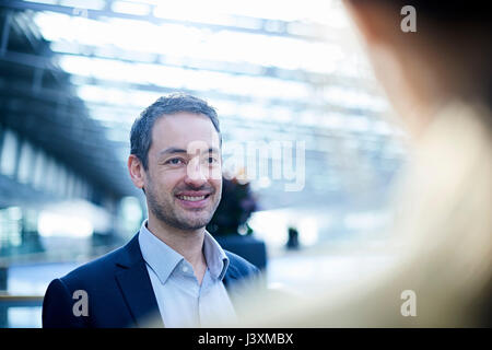 Over shoulder view of businessman in office atrium Stock Photo