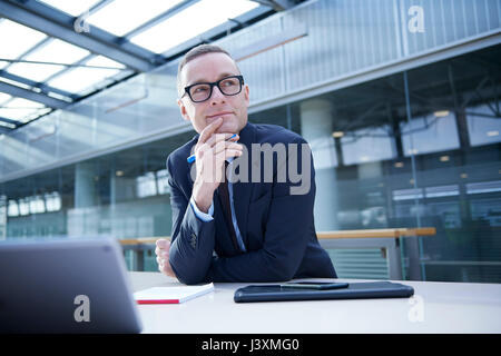 Businessman thinking at office desk Stock Photo