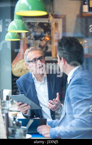 Two businessmen having discussion in restaurant window seat Stock Photo