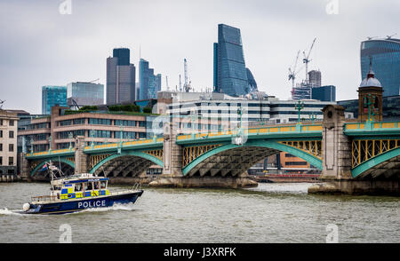 Police patrol boat on the River Thames approaching Southwark Bridge, London Stock Photo