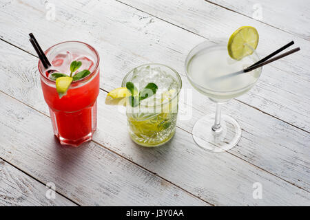 Colorful cocktails set. Mojito , Margarita, red alcohol cocktail on wooden table close up.