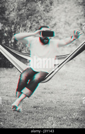 Young bearded man wearing virtual reality goggles. Technology error. Lifestyle VR concept. Stock Photo