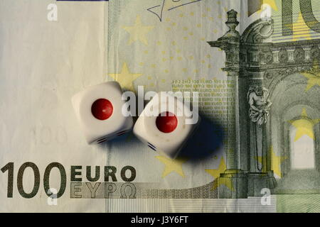 Two white dices on top of a hundred Euro note Stock Photo