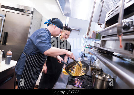 Chefs in kitchen preparing food Stock Photo