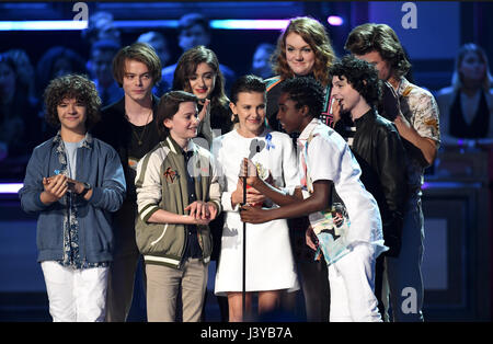 (left to right) Actors Gaten Matarazzo, Charlie Heaton, Noah Schnapp, Natalia Dyer, Shannon Purser, Millie Bobby Brown, Finn Wolfhard, Joe Keery, and Caleb McLaughlin accept the award for Show of the Year for 'Stranger Things' on stage during the 2017 MTV Movie and TV Awards held at The Shrine Auditorium in Los Angeles, USA. Stock Photo