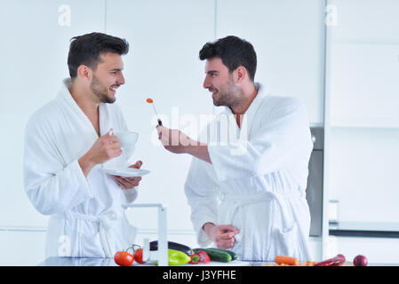 Young gay couple have breakfast in the kitchen in sunny day Stock Photo