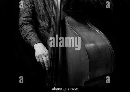 Black and white photograph of a man in playing bass with his face hidden Stock Photo