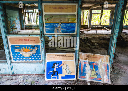 Safety and warning posters in High school No 2 in Pripyat ghost city of Chernobyl Nuclear Power Plant Zone of Alienation in Ukraine Stock Photo
