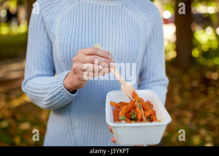 close up of hand holding plate with sweet potato Stock Photo
