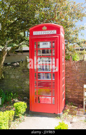 Book exchange in an old red telephone box in the South Hams village of Thurlestone Stock Photo