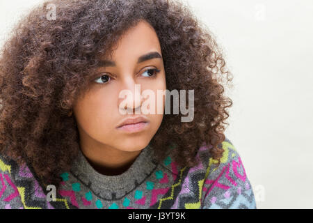 Beautiful mixed race African American girl teenager female young woman sad depressed or thoughtful Stock Photo