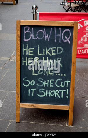 A sign which reads, 'He liked her hair long . . . so she cut it short!', outside a nail bar on Cockburn Street, Edinburgh, Scotland, UK. Stock Photo