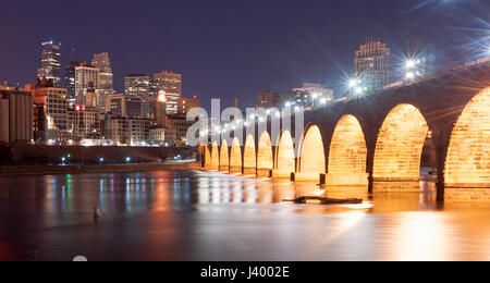 The Stone Arch Bridge dominates the night scene in Saint Paul Minnesota Stock Photo