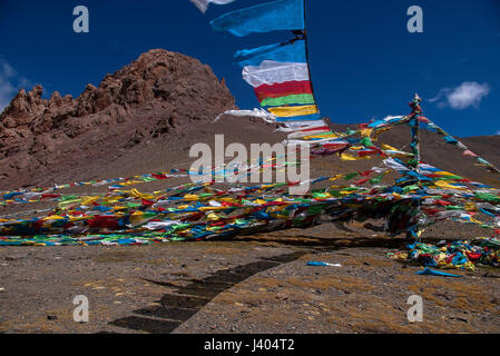 Prayer flags flutter in the wind at a mountain pass on the highway between Lhasa and Namsto Lake in Tibet Stock Photo