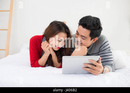 Asian couple using digital tablet at home Stock Photo