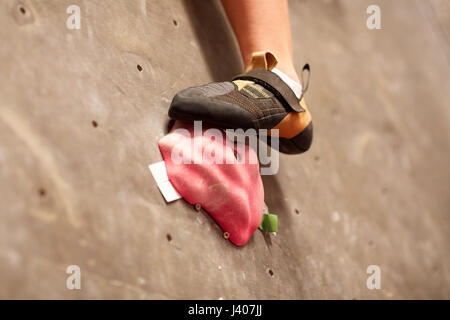 foot of woman on indoor climbing gym wall hold Stock Photo