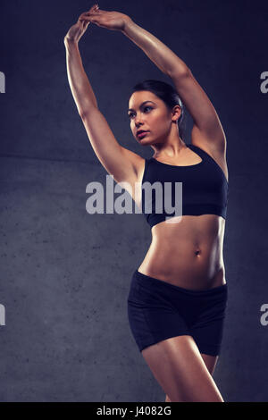 young woman posing and showing muscles in gym Stock Photo