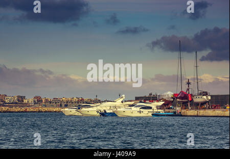 Sailing boats and modern yachts anchored in Tomis touristic harbour of Constanta sea port, in the evening, on the Black Sea shore, Romania. Stock Photo