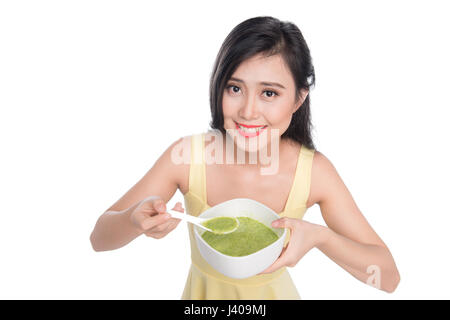 Portrait of asian woman eating/holding a plate of green vegetables soup Stock Photo