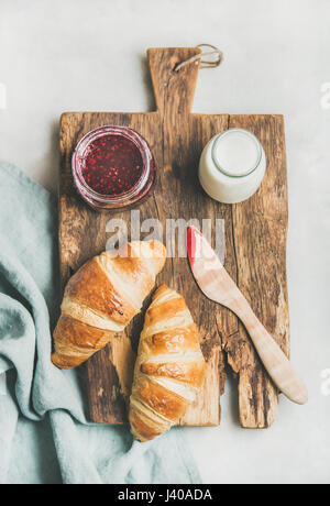 Freshly baked croissants with raspberry jam and milk in bottle Stock Photo