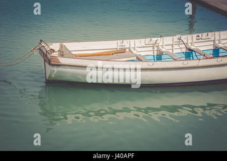 Empty boat on water with reflection, New Zealand Stock Photo