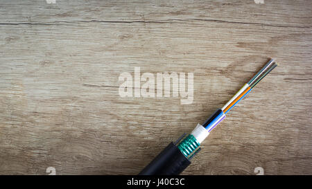 Fiber optics cable on wooden desk. Fiber to the home internet - FTTH Stock Photo