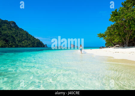 Idyllic View of Woman walking in Tup Island Beach Agasint Sky and other Islands Stock Photo