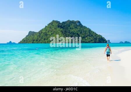 Woman Walking On Beach Against Blue Sky and Island Stock Photo