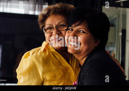 Portrait of mother and adult daughter hugging Stock Photo