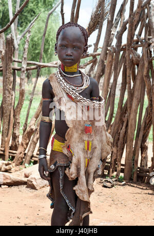 OMO VALLEY - SOUTHWESTERN ETHIOPIA - JANUARY 2nd: Young unidentified girl of the Hamer Tribe standing portrait with traditionall ornaments, in January Stock Photo