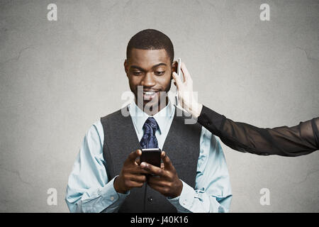 Closeup portrait happy smiling corporate business man reading good news on smart cell phone simultaneously having conversation on second mobile isolat Stock Photo