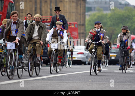 Tweed Run cyclist participants in London crossing Westminster Bridge passing the Houses of Parliament Stock Photo