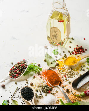 Spices in different spoons on a stone white background. A scattering of spices. Stock Photo