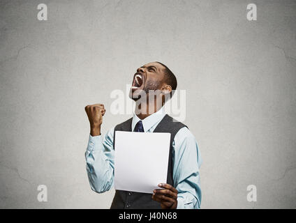 Closeup portrait angry, mad, screaming business man holding paper, document, screaming, looking up isolated grey background. Negative emotions, facial Stock Photo
