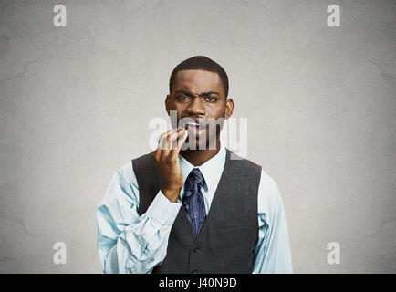 Closeup portrait handsome sad young executive man, student, worker touching face having bad pain, tooth ache, isolated grey background. Negative human Stock Photo