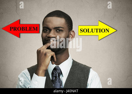 Closeup portrait business man thinking about something, finger on lips looking for solution of problem isolated black background. Emotion facial expre Stock Photo