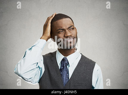 Closeup portrait handsome company business man thinking, daydreaming trying hard to remember something looking up isolated black background. Human emo Stock Photo