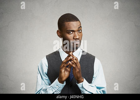 Closeup portrait, sneaky, sly, scheming young business man, worker trying to plot something, screw someone, isolated black background. Negative human  Stock Photo