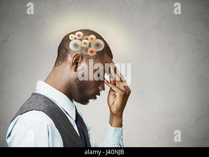 Closeup side view profile headshot thoughtful man, young guy thinking hard, gear mechanism, illustration over head isolated grey wall background. Huma