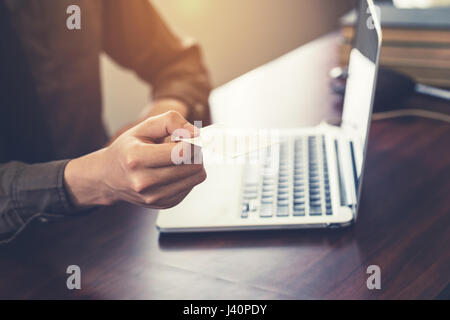 Business man holding white business card in the office. Vintage toned. Stock Photo