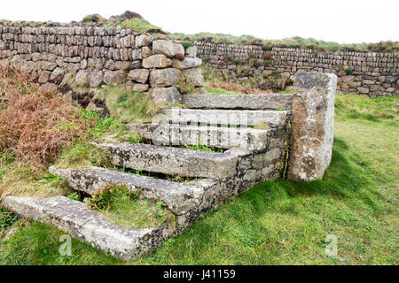 A flight of stone steps in a dry stone wall built from granite blocks of different sizes and colours at Cape Cornwall, Cornwall, England, UK Stock Photo