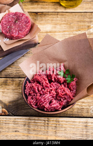 Organic raw ground beef meat and burger steak cutlets ready to prepare on rustic table Stock Photo