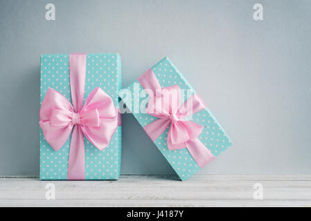 Blue polka dots gift boxes with pink ribbons on blue background Stock Photo