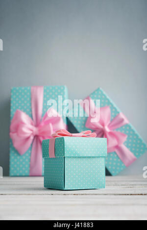 Blue polka dots gift boxes with pink ribbons on blue background Stock Photo